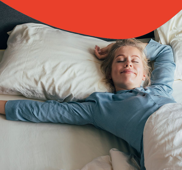 Frau liegt in einem Hotelbett