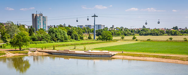 Mannheim BUGA mit See, Grünfläche und Seilbahn.