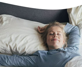 Frau liegt in einem Hotelbett
